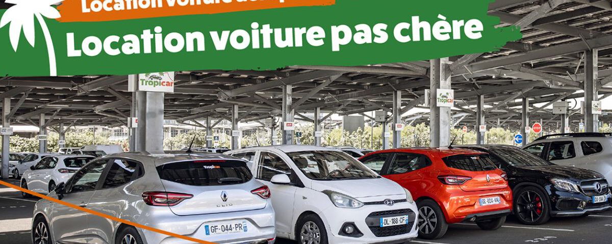Une sélection de véhicules de location Tropicar garés sur le parking de l'aéroport Roland Garros à La Réunion, illustrant la diversité des modèles disponibles à des prix économiques