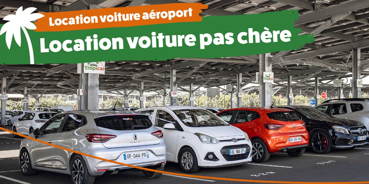 Une sélection de véhicules de location Tropicar garés sur le parking de l'aéroport Roland Garros à La Réunion, illustrant la diversité des modèles disponibles à des prix économiques