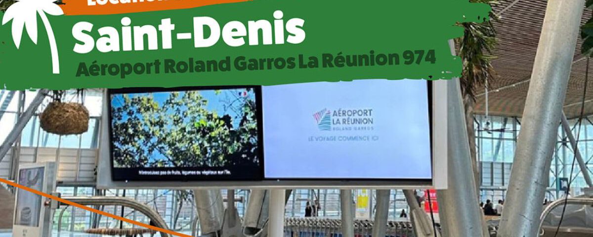 Photographie représentant l'intérieur de l'aéroport de Saint-Denis de La Réunion, montrant le hall principal situé avant les comptoirs de location de voiture