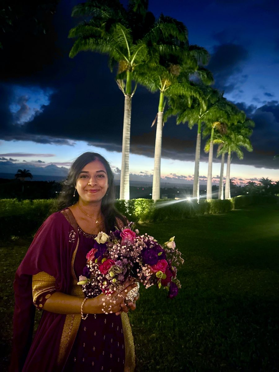 Sakina, qui fait revivre Mariage Réunion, tenant un bouquet lors d'un mariage à La Réunion au coucher du soleil